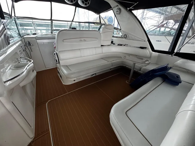 Slide: The Image of 1997 Sea Ray 400 Sundancer interior with white seating and wooden flooring. - 34