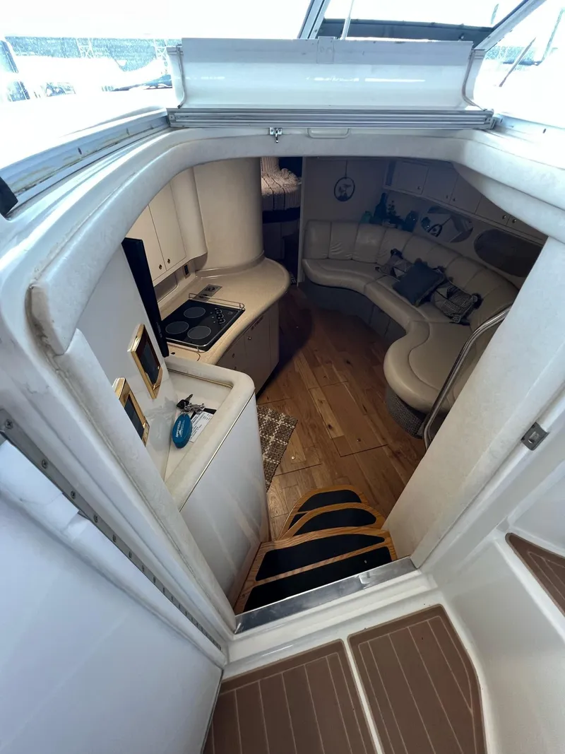 Slide: The Image of 1997 Sea Ray 400 Sundancer yacht on calm water, featuring sleek design and black canopy. - 4