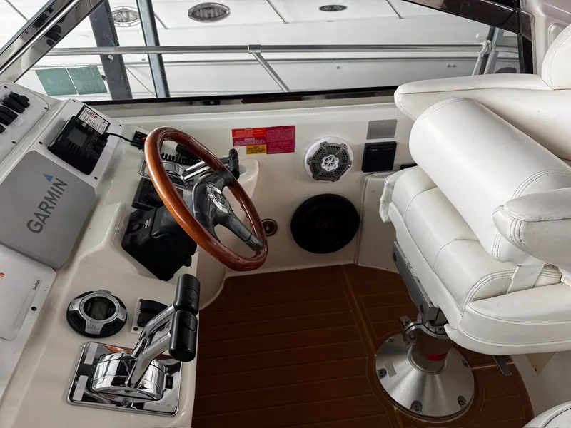 Slide: The Image of 1997 Sea Ray 400 Sundancer helm with steering wheel and navigation controls. - 41