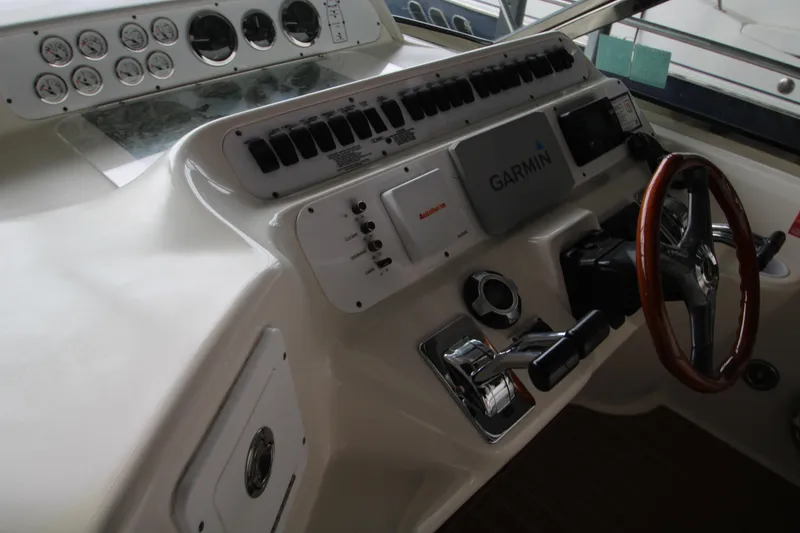 Slide: The Image of 1997 Sea Ray 400 Sundancer helm with Garmin navigation, wooden steering wheel, and white captain's chair. - 42