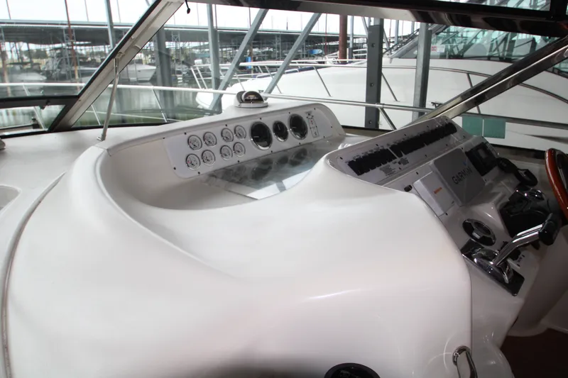 Slide: The Image of 1997 Sea Ray 400 Sundancer helm with steering wheel and navigation equipment. - 44