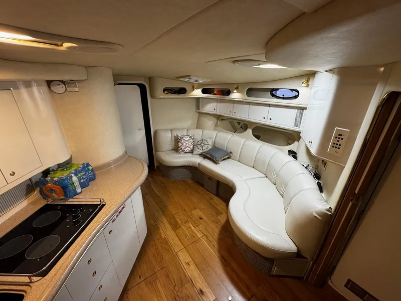 Slide: The Image of Luxurious interior of 1997 Sea Ray 400 Sundancer with white leather seating and wooden flooring. - 9