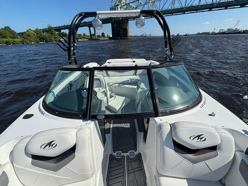 Slide: The Image of 2016 Monterey 238 Super Sport boat on water near a bridge, featuring sleek design and seating. - 13