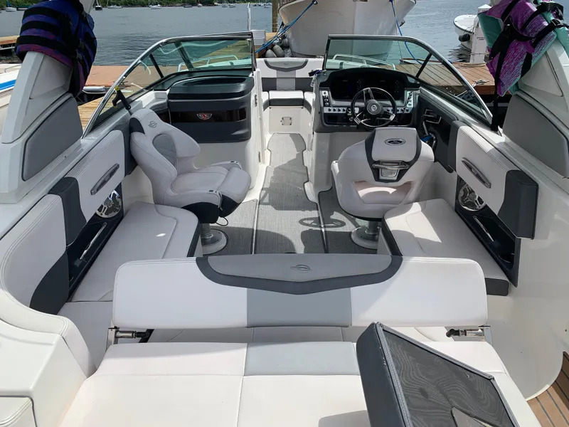 Slide: The Image of 2019 Chaparral 257 SSX boat interior with seating and steering wheel, docked by the water. - 25