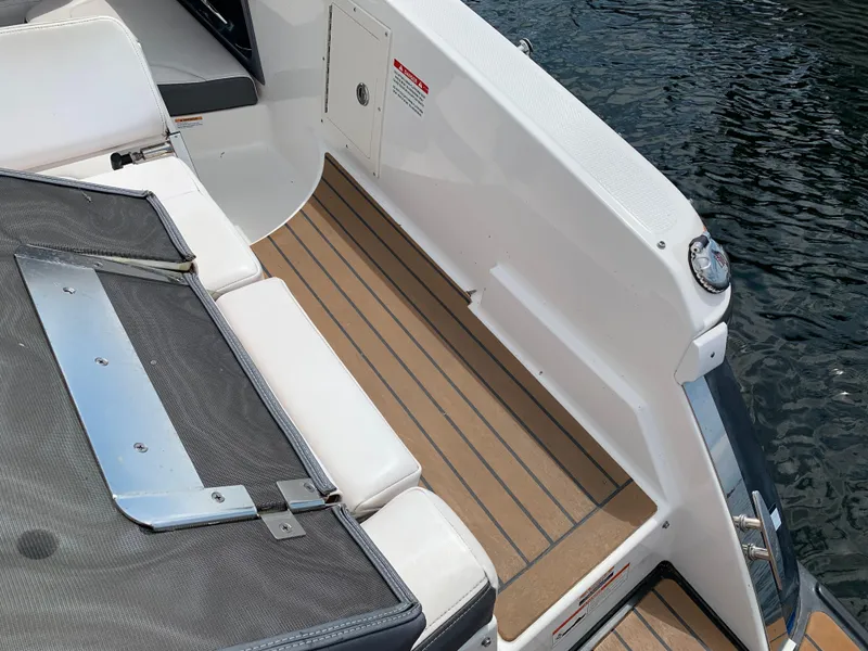 Slide: The Image of 2019 Chaparral 257 SSX boat deck with white seating and wood-style flooring. - 26