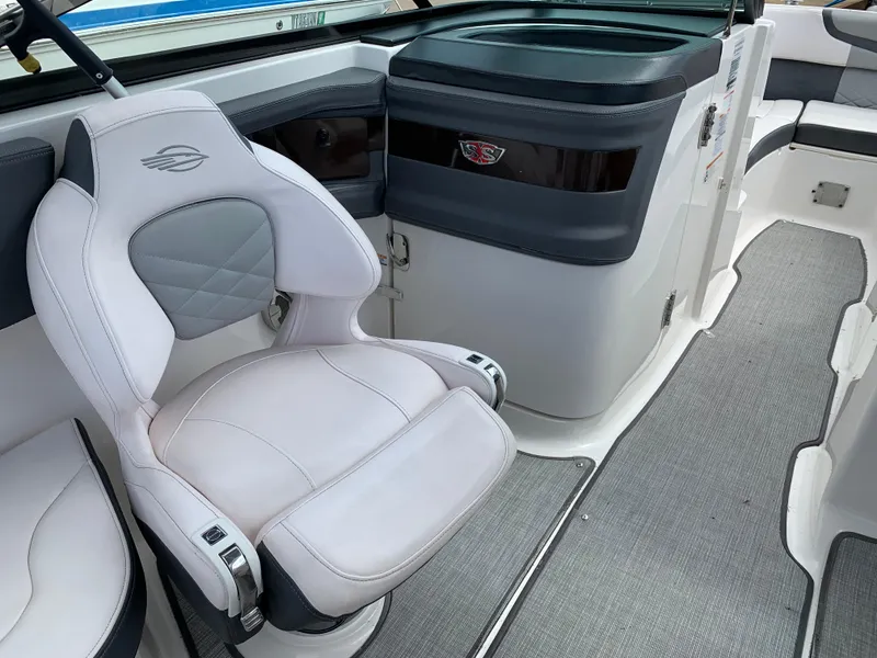 Slide: The Image of 2019 Chaparral 257 SSX boat interior with white captain's chair and sleek dashboard. - 30