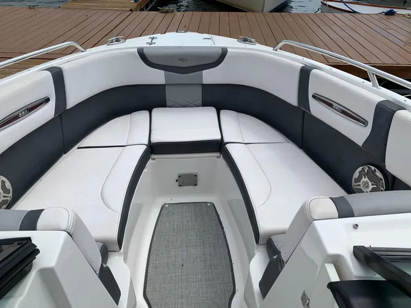 Slide: The Image of 2019 Chaparral 257 SSX boat interior with white and gray seating, docked by wooden pier. - 31