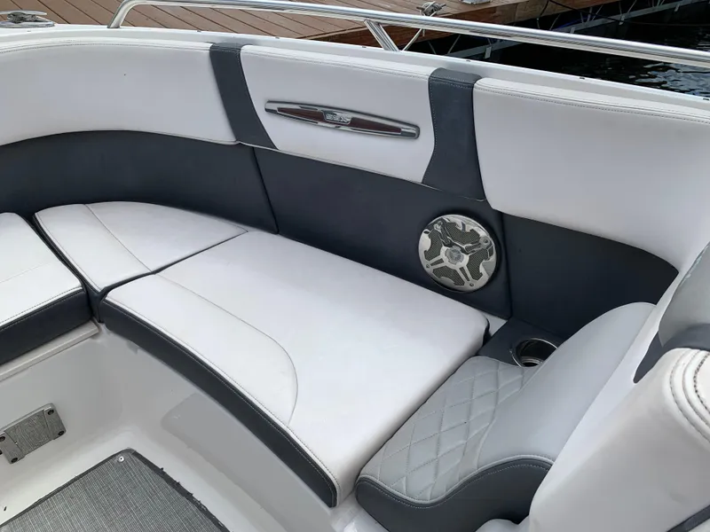 Slide: The Image of 2019 Chaparral 257 SSX boat interior with white and gray seating, speaker, and cup holder. - 32