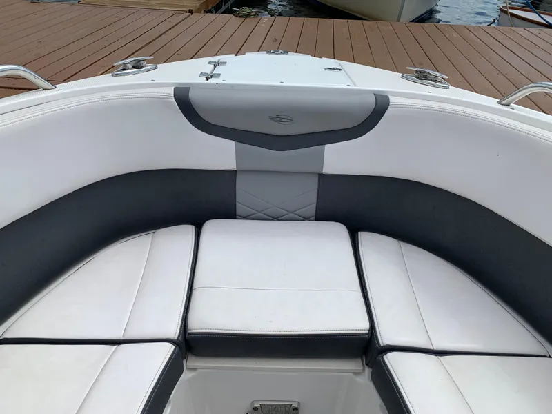 Slide: The Image of 2019 Chaparral 257 SSX boat interior with white and gray seating at dock. - 33
