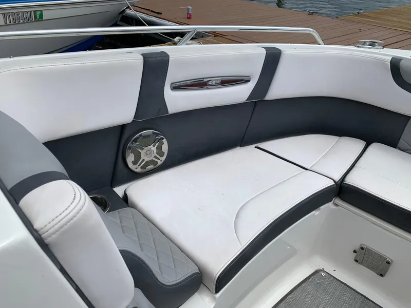 Slide: The Image of 2019 Chaparral 257 SSX boat interior with white and gray seating, speaker, and cup holder. - 34