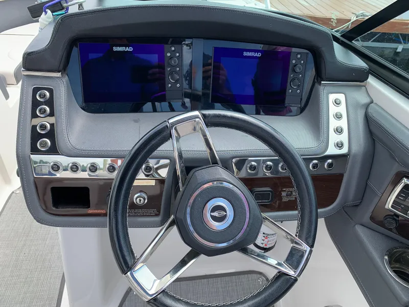Slide: The Image of 2019 Chaparral 257 SSX boat dashboard with dual Simrad displays and steering wheel. - 39