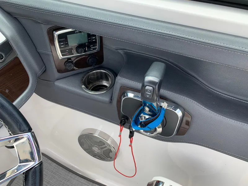 Slide: The Image of 2019 Chaparral 257 SSX boat dashboard with controls, cup holder, and audio system. - 42