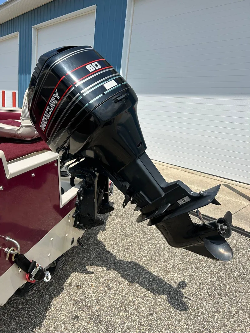 Slide: The Image of 1997 Crestliner 1650 Sportfish with Mercury 90 outboard motor, parked outdoors. - 11