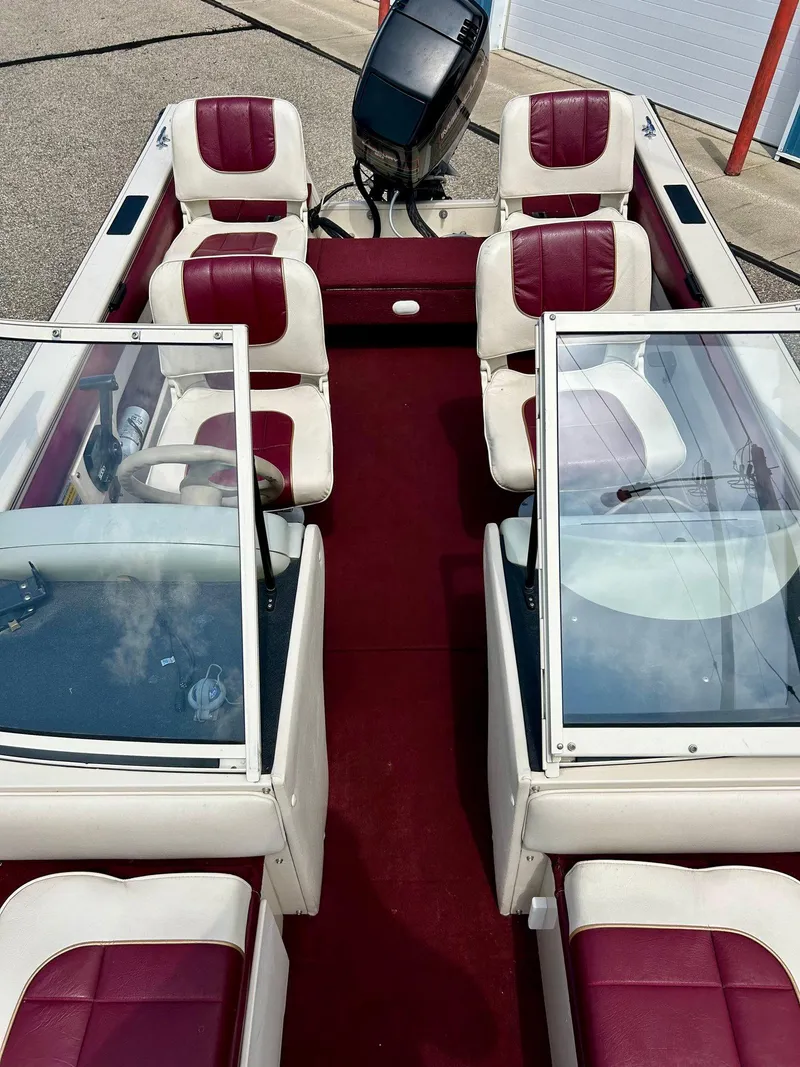 Slide: The Image of 1997 Crestliner 1650 Sportfish boat with red and white seating, glass windshields, and outboard motor. - 6