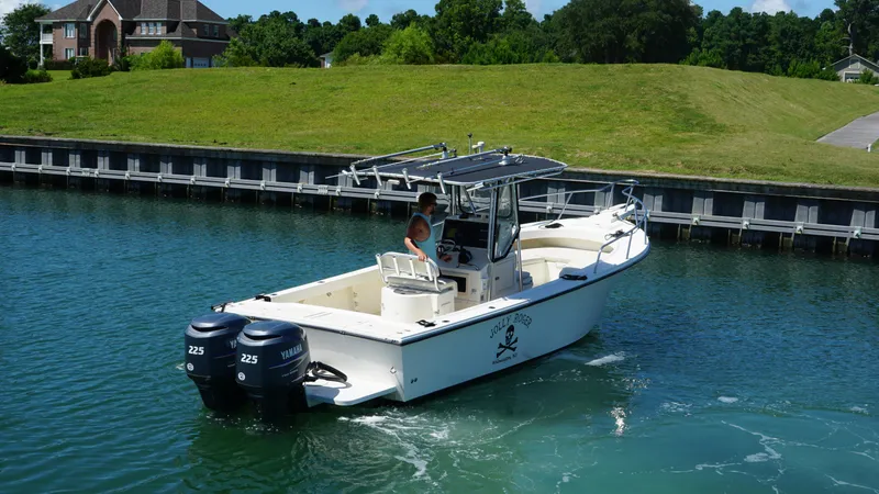 The Image of 2005 Parker 2501 Center Console boat with dual Yamaha engines on a calm waterway. - 1