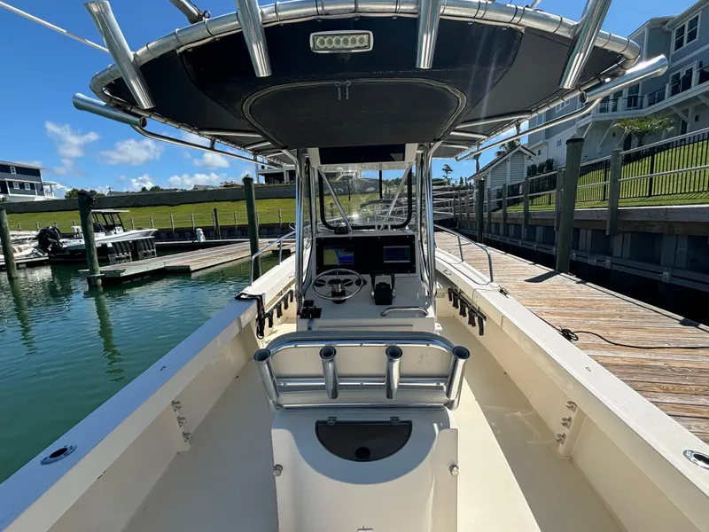 Slide: The Image of 2005 Parker 2501 Center Console boat docked at a marina under clear blue skies. - 12