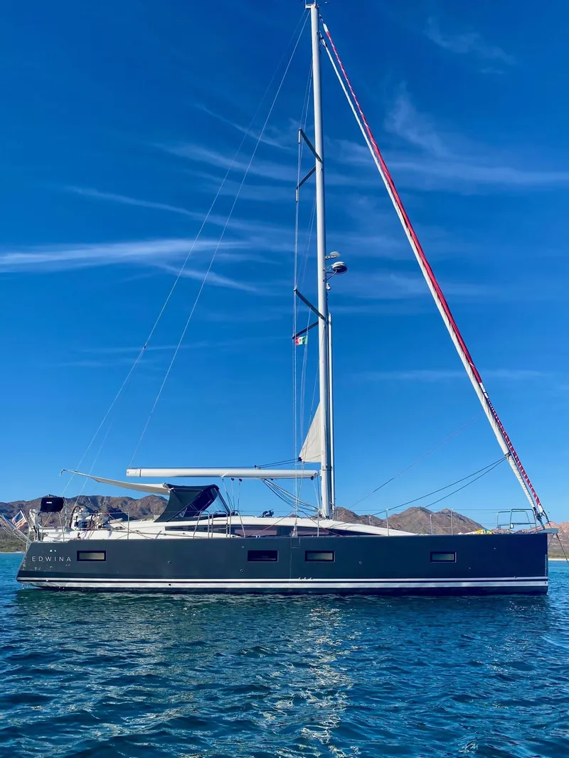 Slide: The Image of 2018 Jeanneau 54 sailboat on calm water under clear blue sky. - 11