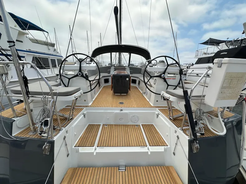 Slide: The Image of 2018 Jeanneau 54 yacht cockpit with dual steering wheels and teak decking. - 24