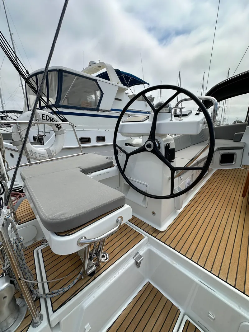 Slide: The Image of 2018 Jeanneau 54 yacht cockpit with steering wheel and teak flooring. - 26