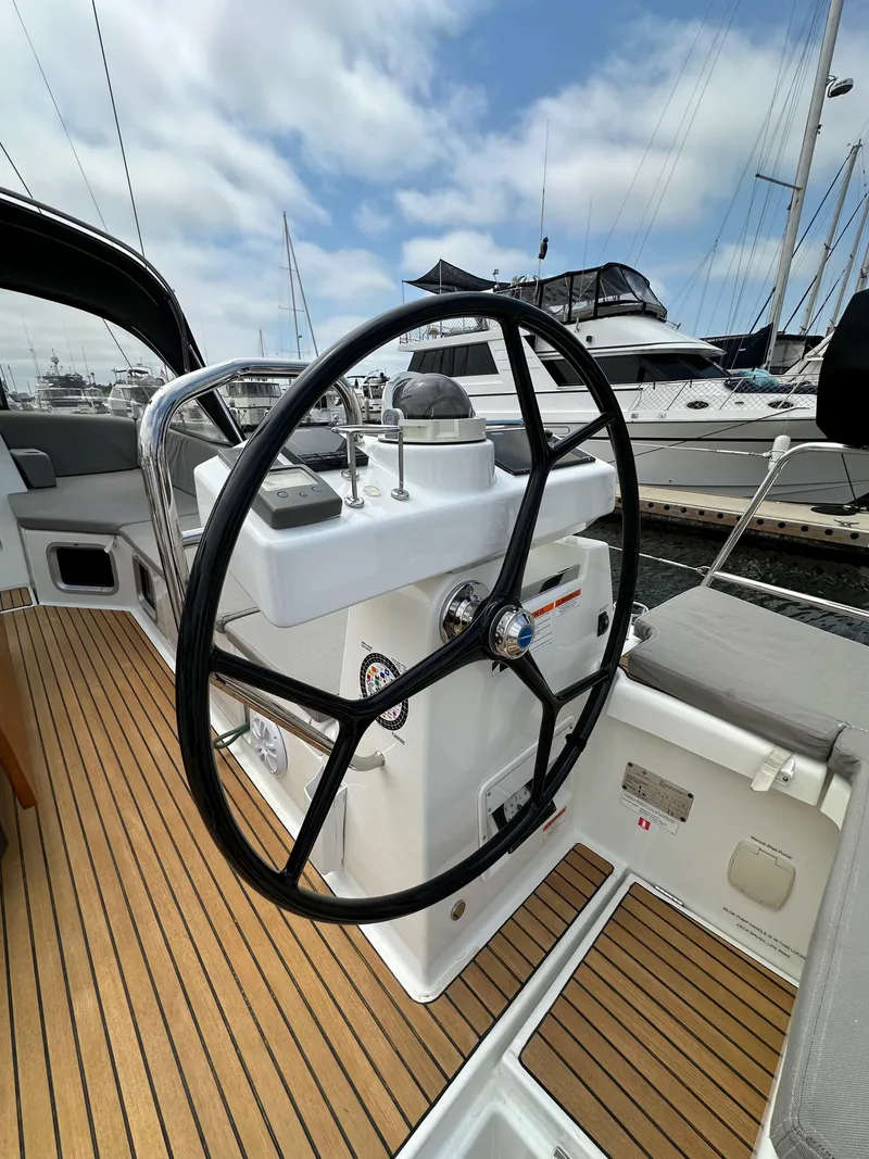 Slide: The Image of Steering wheel of a 2018 Jeanneau 54 yacht, docked at a marina. - 29
