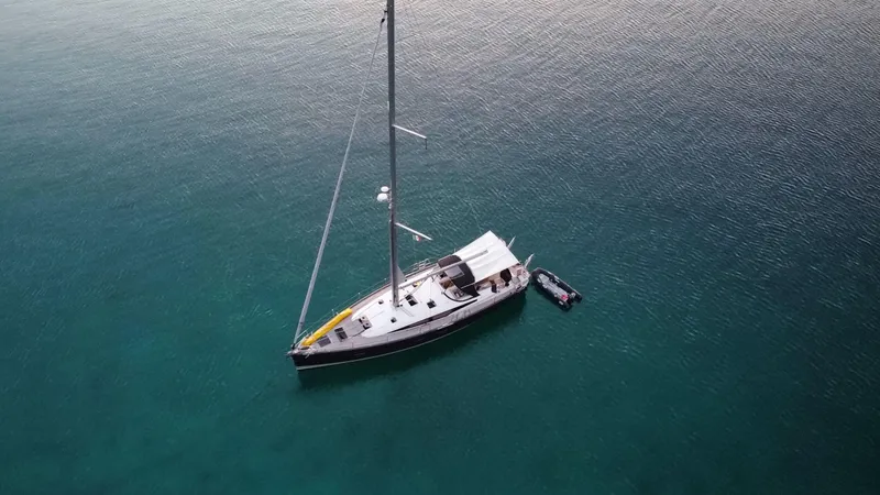 Slide: The Image of Aerial view of 2018 Jeanneau 54 sailboat anchored in calm, clear waters. - 6