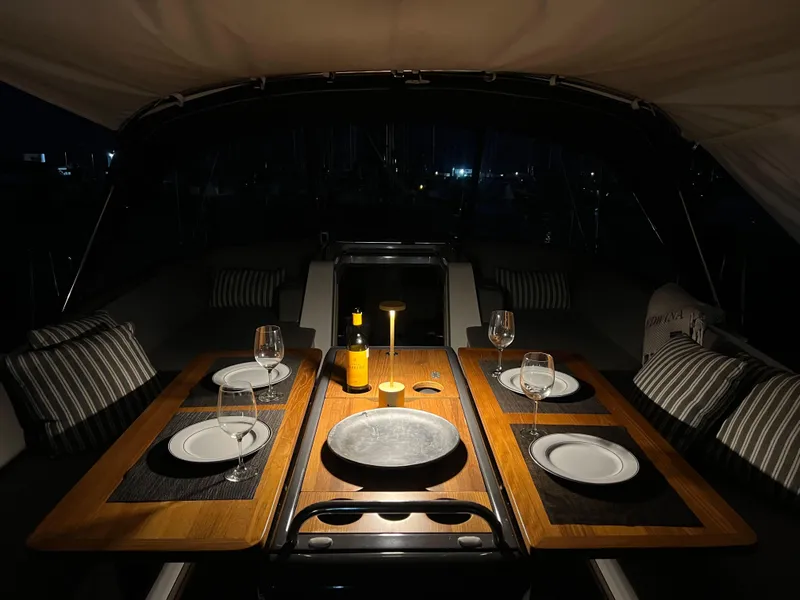 Slide: The Image of Luxurious dining setup on a 2018 Jeanneau 54 yacht at night. - 68