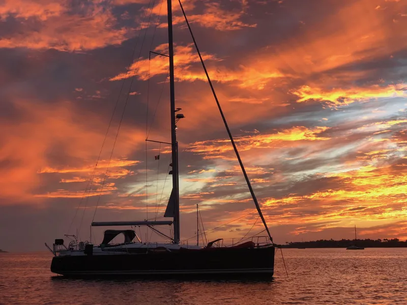 Slide: The Image of Sailing yacht Jeanneau 54 (2018) silhouetted against a vibrant sunset sky. - 9