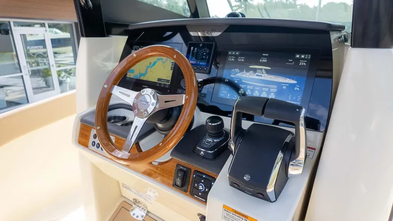 Slide: The Image of 2025 Chris-Craft Catalina 28 dashboard with wooden steering wheel and modern navigation display. - 21