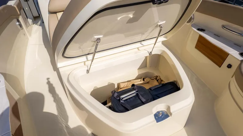 Slide: The Image of Open storage compartment on 2025 Chris-Craft Catalina 28 boat with bags inside. - 27