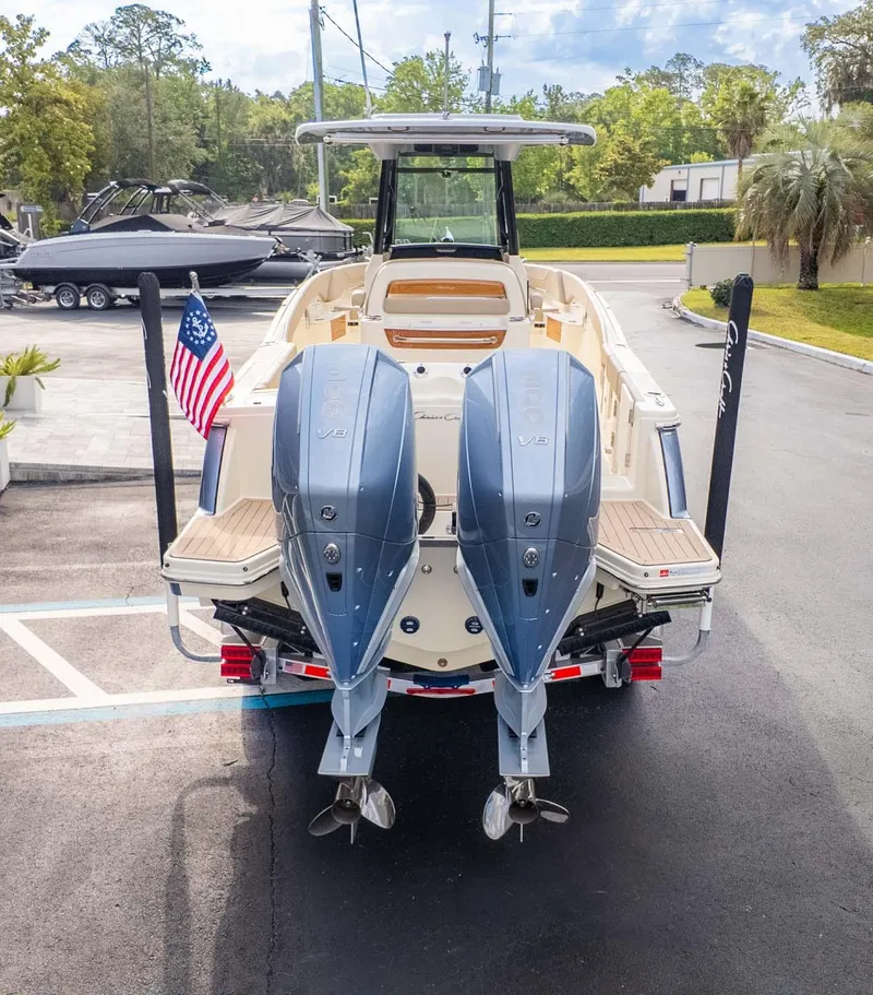 Slide: The Image of 2025 Chris-Craft Catalina 28 with dual outboard engines, rear view, parked on pavement. - 3