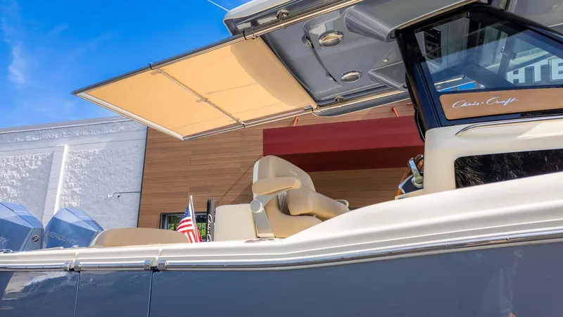 Slide: The Image of 2025 Chris-Craft Catalina 28 boat with canopy, American flag, and modern design. - 32