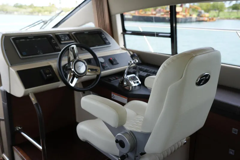 Slide: The Image of 2015 Sea Ray 510 Flybridge helm with modern controls and white captain's chair. - 17