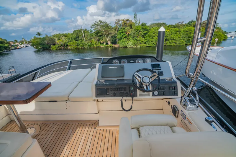Slide: The Image of 2015 Sea Ray 510 Fly yacht helm with scenic river view. - 23