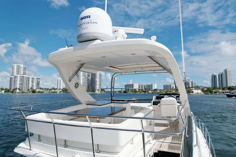Slide: The Image of 2015 Sea Ray 510 Fly yacht on water with city skyline in background. - 5