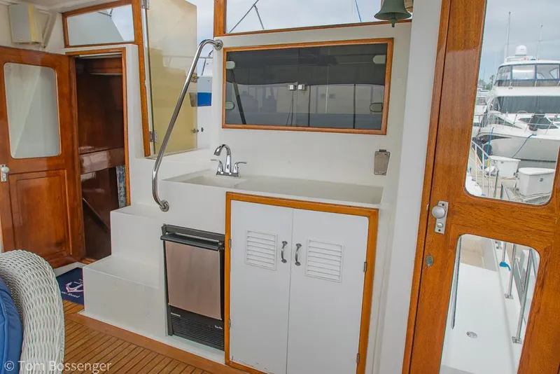 Slide: The Image of 1987 Lien Hwa 47 Elegant MKII Motoryacht interior with sink, wooden doors, and marina view. - 43