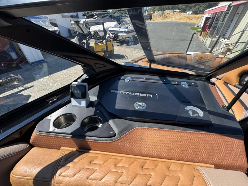 Slide: The Image of 2025 Centurion RI 245 boat dashboard with cup holders and wireless charging station. - 22
