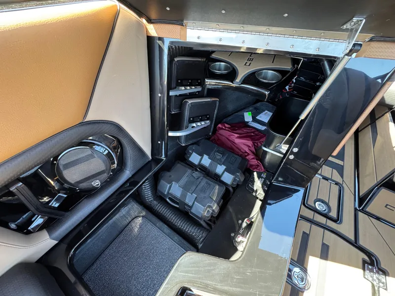 Slide: The Image of Interior of 2025 Centurion RI 245 boat showing storage compartment and speaker system. - 24