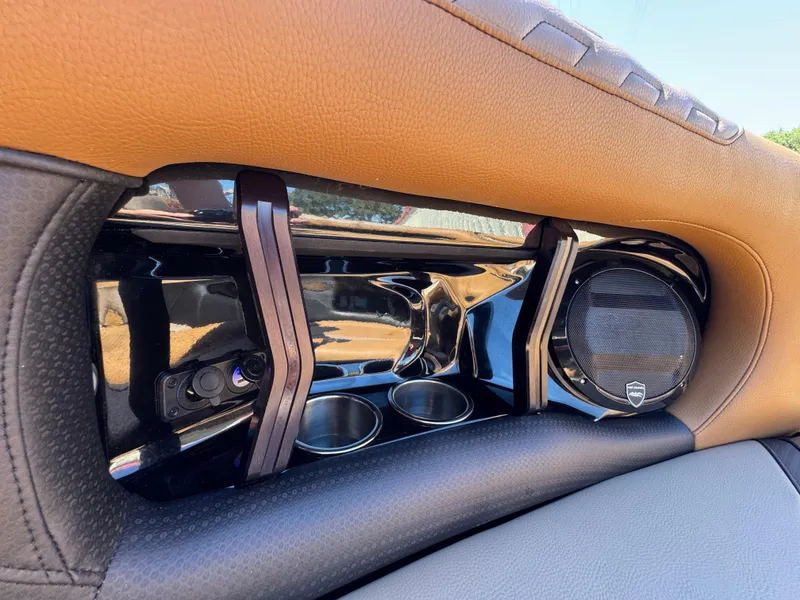 Slide: The Image of 2025 Centurion RI 245 interior detail with speaker and cup holders, featuring brown and black leather. - 29