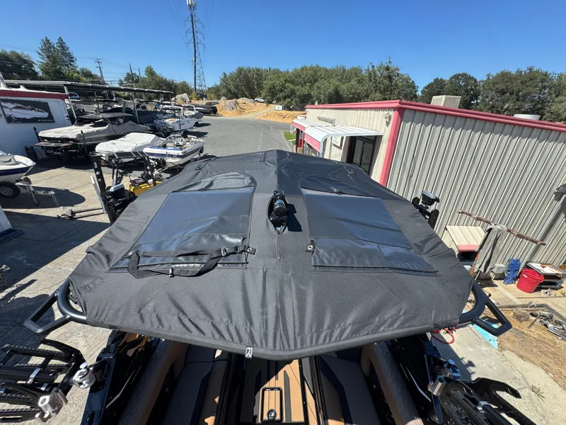 Slide: The Image of 2025 Centurion RI 245 boat with black cover in a marina setting. - 46