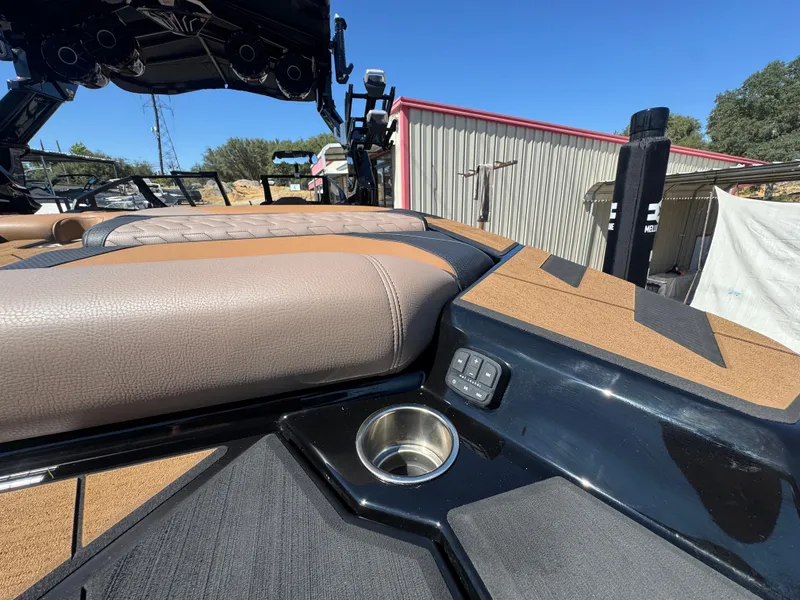 Slide: The Image of 2025 Centurion RI 245 boat interior with cup holder and seating, under clear blue sky. - 47