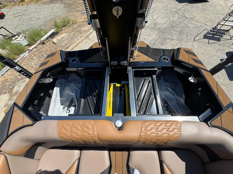 Slide: The Image of 2025 Centurion RI 245 boat interior with open storage compartments and brown leather seating. - 7