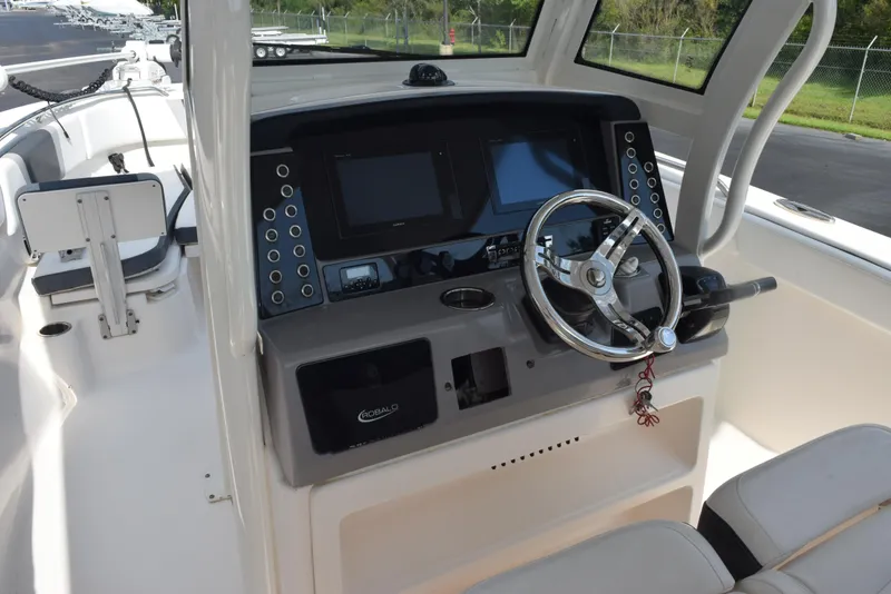 Slide: The Image of 2019 Robalo R272 Center Console boat dashboard with steering wheel and control panel. - 10