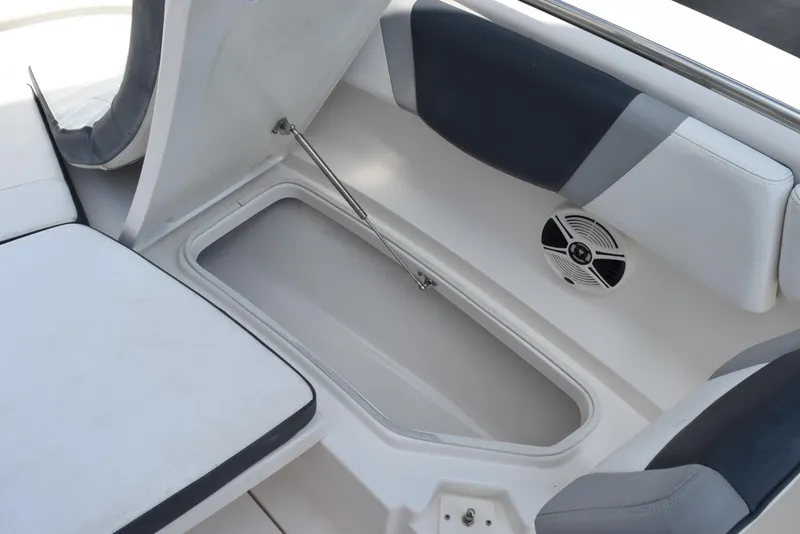 Slide: The Image of 2019 Robalo R272 Center Console boat storage compartment with cushioned seating and speaker. - 18