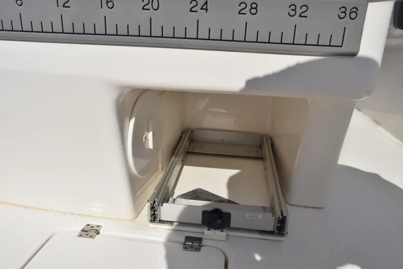 Slide: The Image of 2019 Robalo R272 Center Console storage compartment with measuring scale. - 21