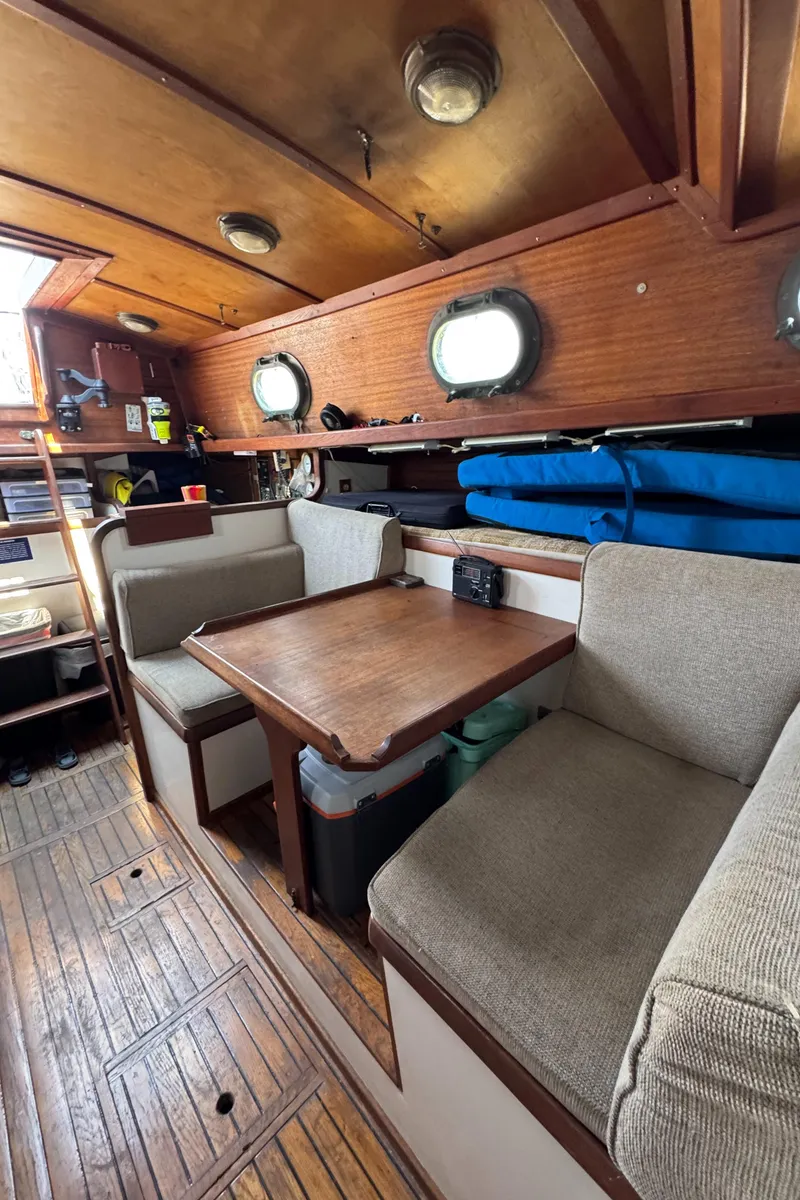 Slide: The Image of Interior of 1985 Bluewater Ingrid 38 sailboat with wooden furnishings and cozy seating area. - 23