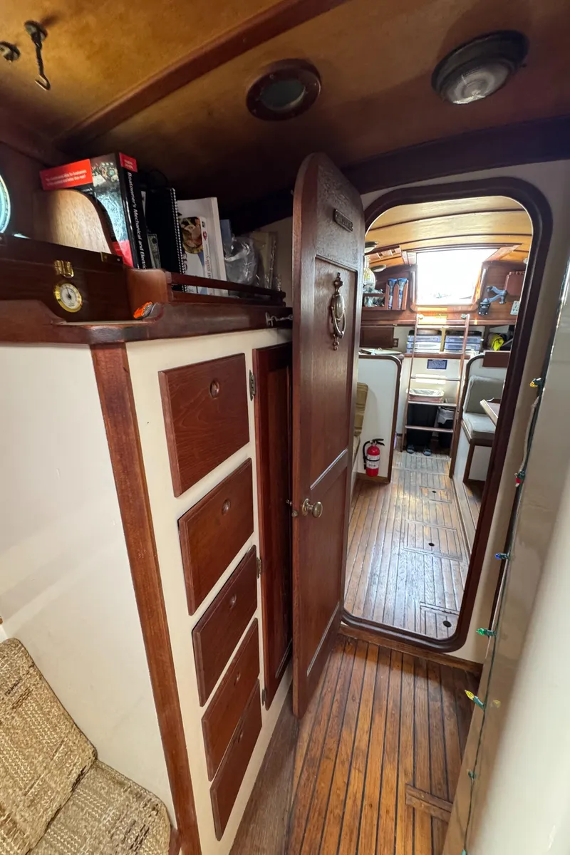 Slide: The Image of Interior of 1985 Bluewater Ingrid 38 sailboat with wooden cabinetry and cozy seating area. - 27