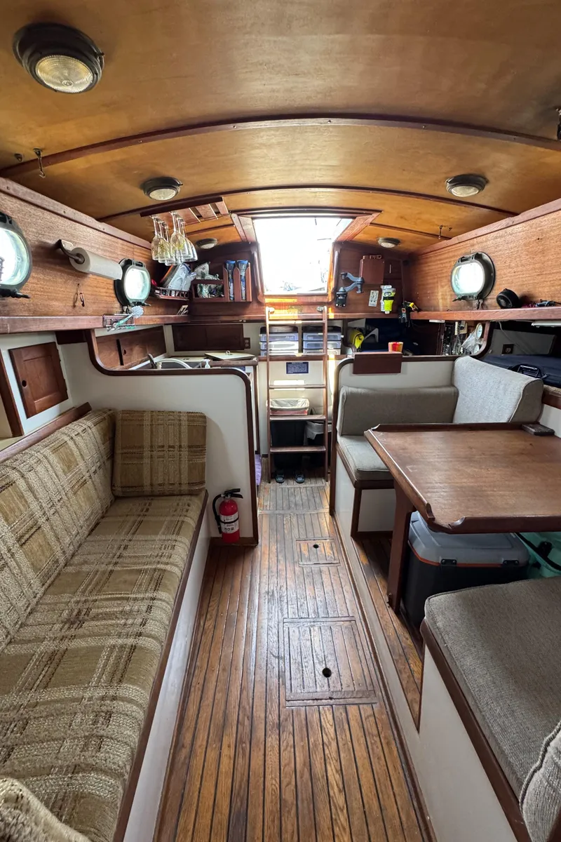 Slide: The Image of Interior of 1985 Bluewater Ingrid 38 sailboat with wooden flooring and cozy seating area. - 33