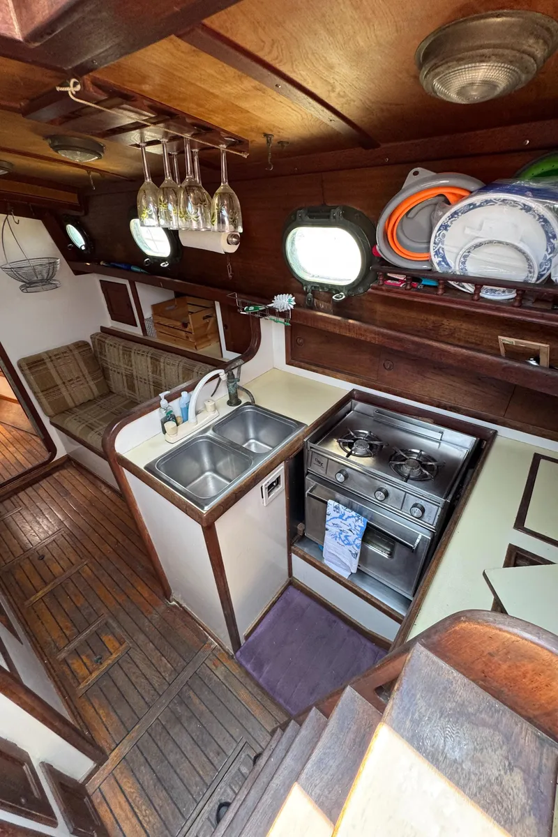 Slide: The Image of Interior of 1985 Bluewater Ingrid 38 sailboat with kitchen and seating area. - 38