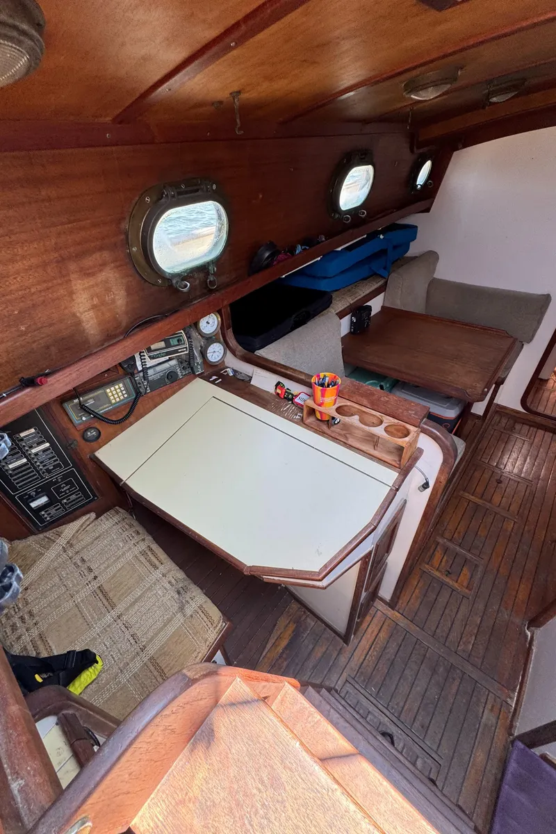 Slide: The Image of 1985 Bluewater Ingrid 38 sailboat interior with wooden furnishings and navigation equipment. - 39