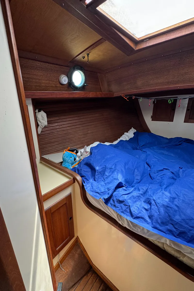 Slide: The Image of Cozy cabin interior of 1985 Bluewater Ingrid 38 sailboat with wooden accents and blue bedding. - 42